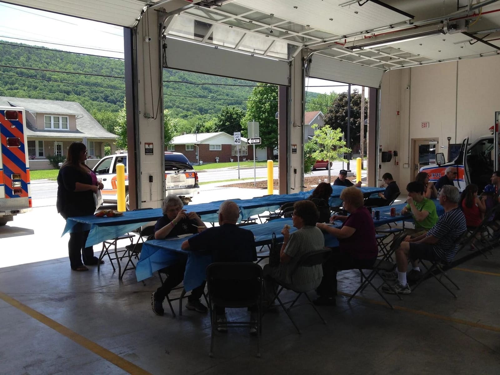 Children gathered in the station bay learning about the ambulance from rescue squad members